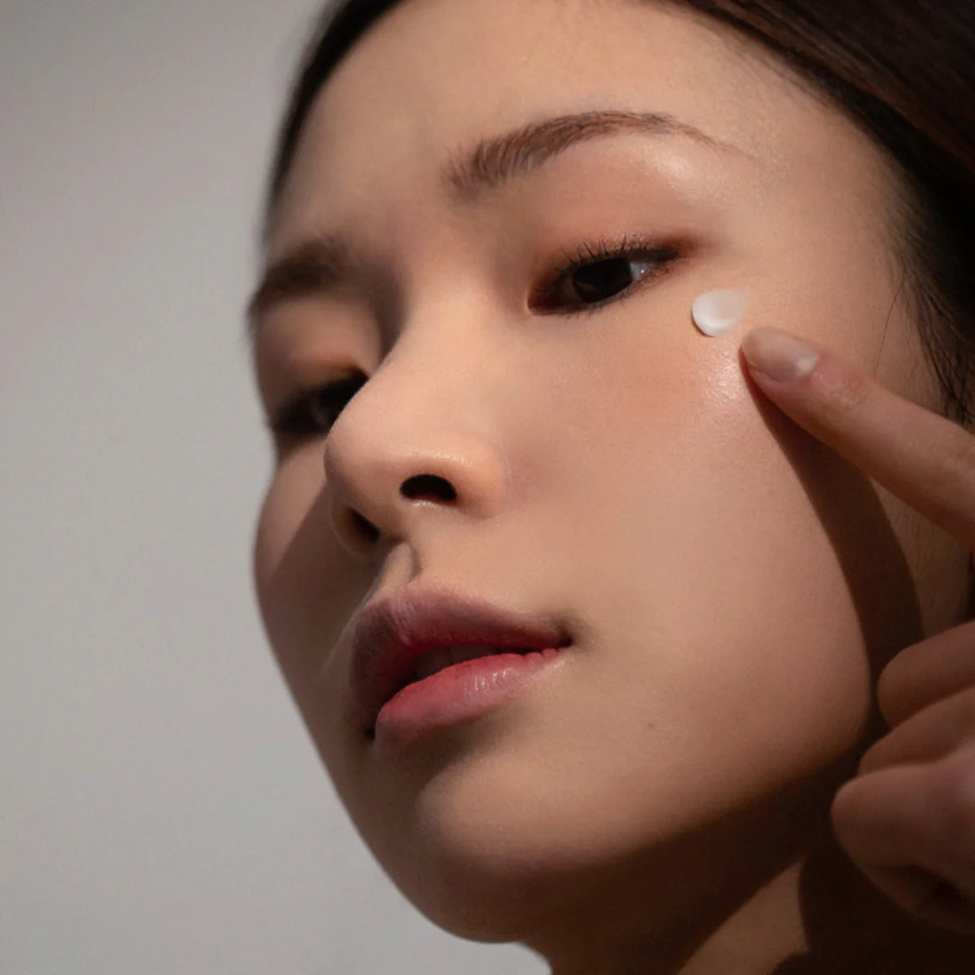 model applying Haruharu Wonder Black Rice Bakuchiol Eye Cream under eyes