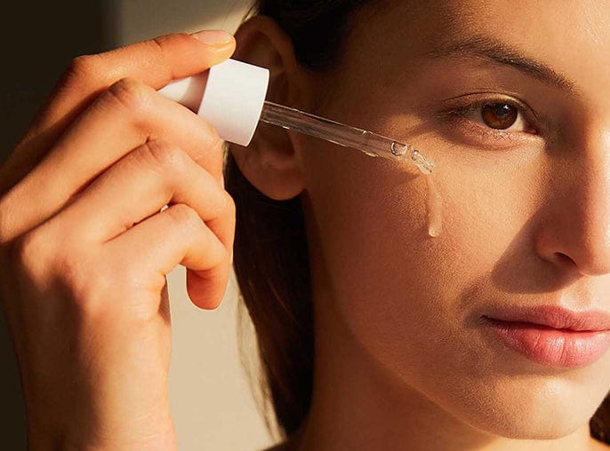 Close up view of the clear, watery texture of the Centella Ampoule on model skin